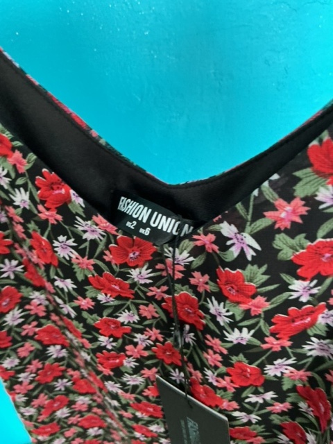 Zbliżenie na dekolt i kwiatowy wzór bluzki Fashion Union