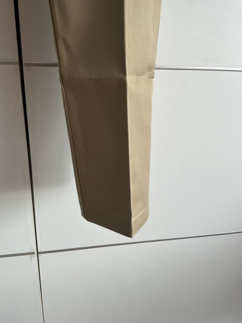 Zbliżenie na nogawkę beżowych spodni męskich Dickies
