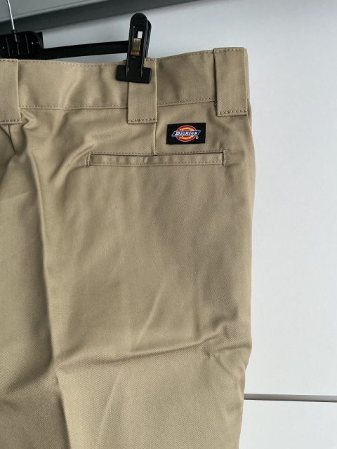 Zbliżenie na tylną kieszeń beżowych spodni męskich Dickies