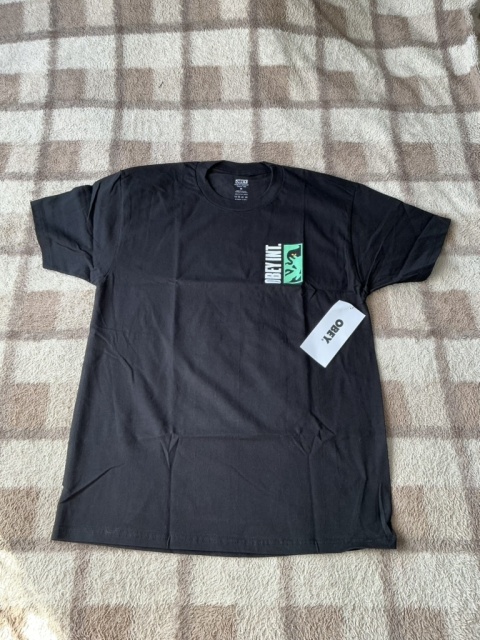 Czarny T-shirt OBEY z zielono-białym nadrukiem, widok całej koszulki z przodu.